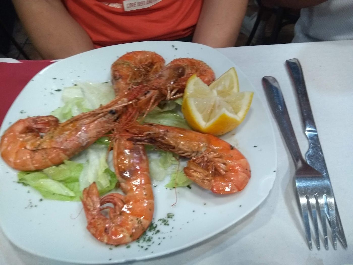 Plato de espárragos blancos envueltos en salmón marinado, presentado sobre lechuga.